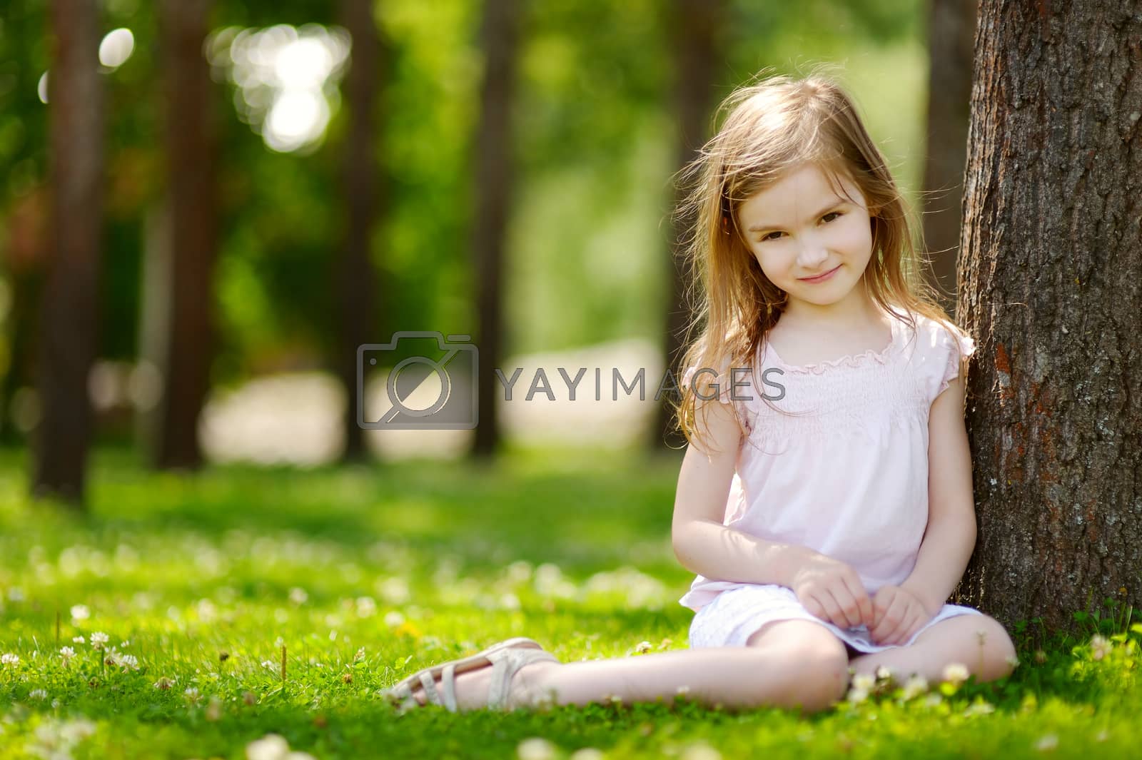 Royalty free image of Cute little girl sitting on a clover field by maximkabb