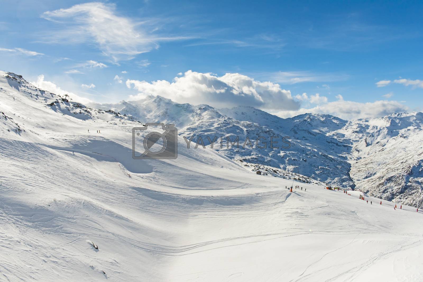 Royalty free image of Skiers on a piste in alpine ski resort by paulvinten