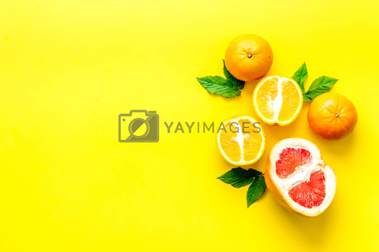 Royalty free image of Oranges and grapefruits with leaves on table top view copy space by 9dreamstudio