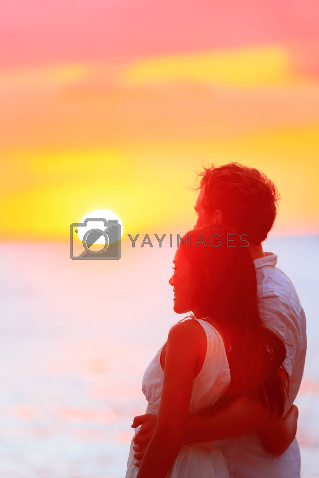 Royalty free image of Happy couple watching sunset at beach vacation by Maridav