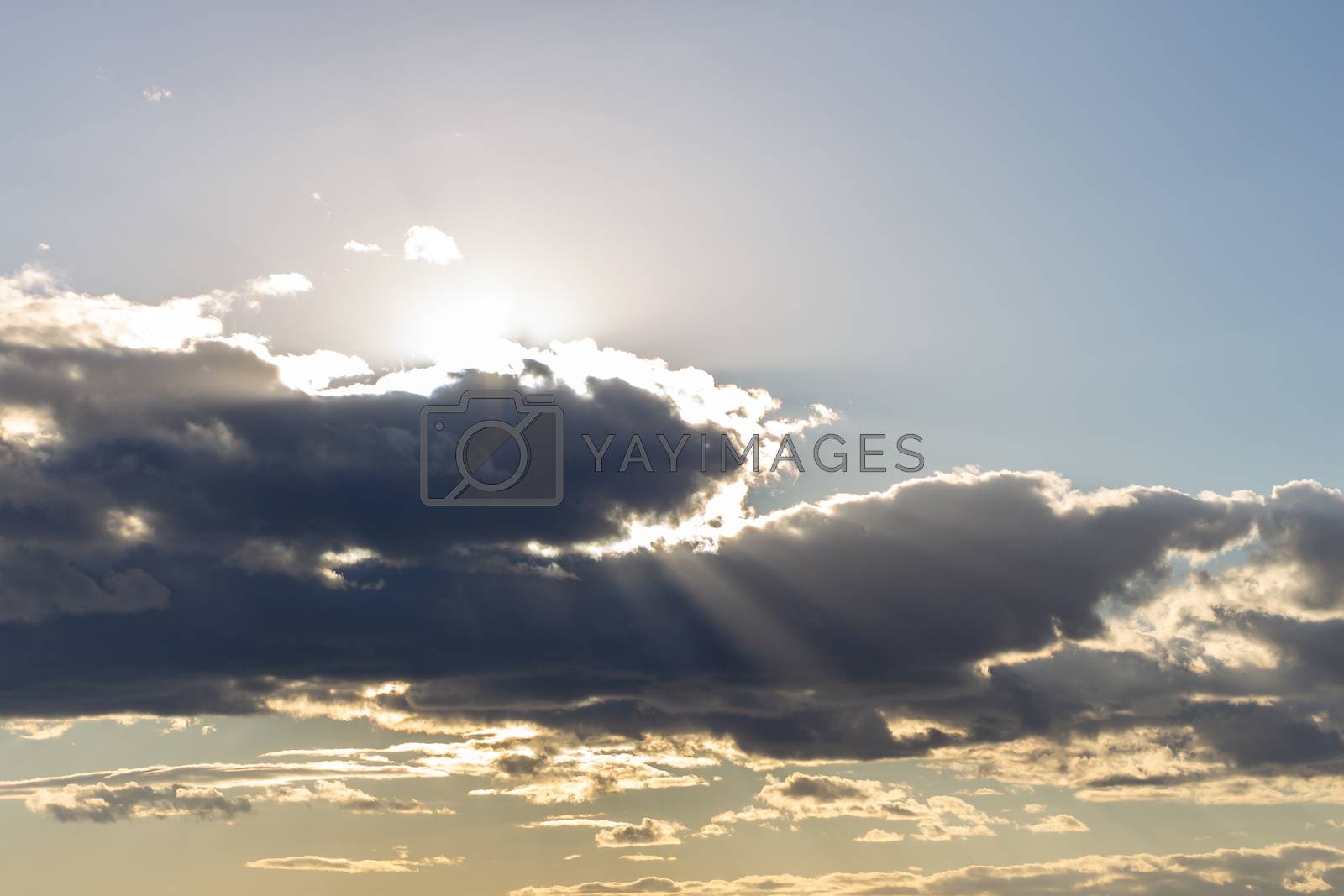Royalty free image of Sun rays breaking through cumulus clouds. The concept of divine light, a glimmer of hope or overcoming difficulties. Spiritual religious background. by Eugene_Yemelyanov
