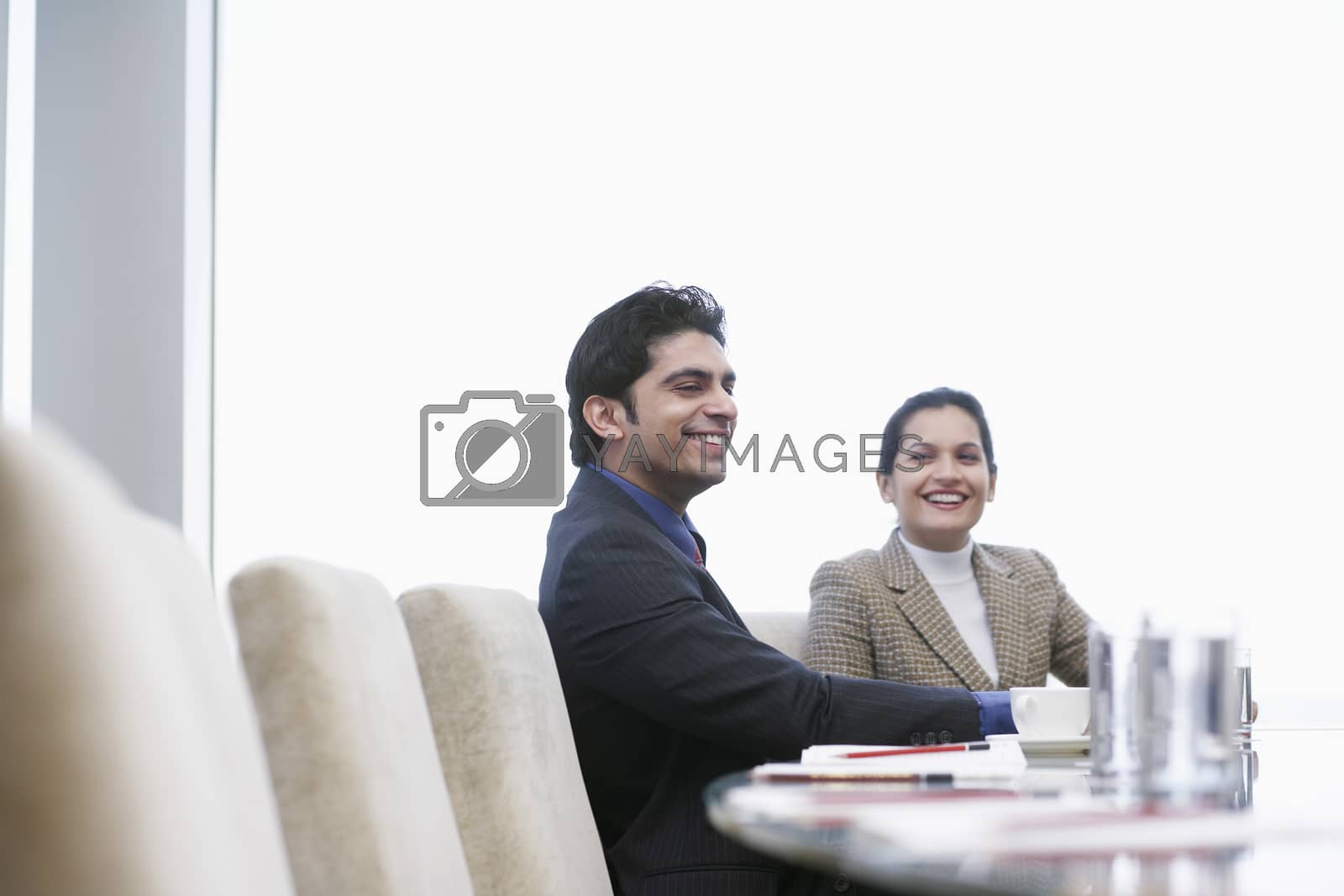 Royalty free image of Business associates smiling having business meeting by moodboard