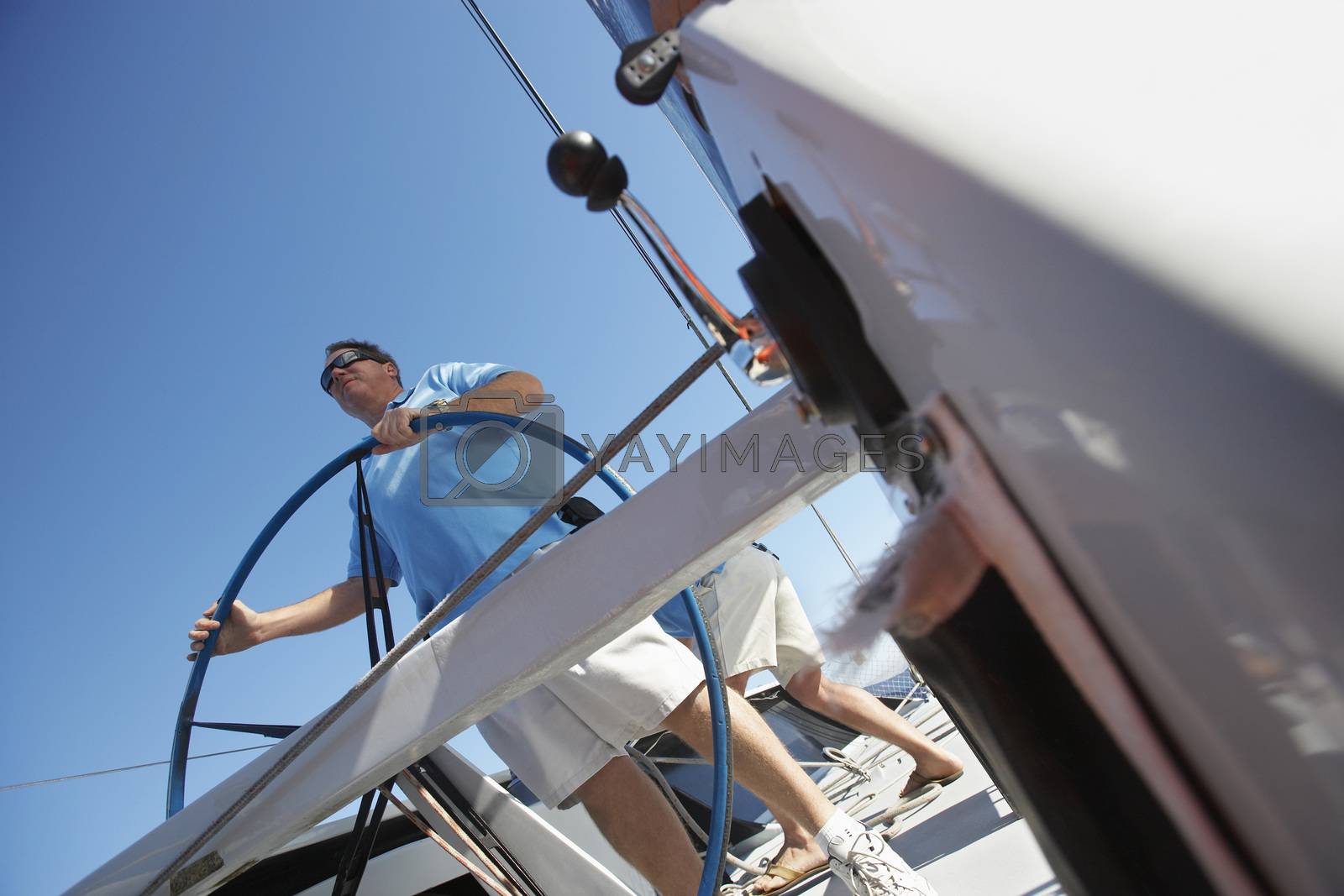 Royalty free image of Male sailor at steering wheel of boat by moodboard