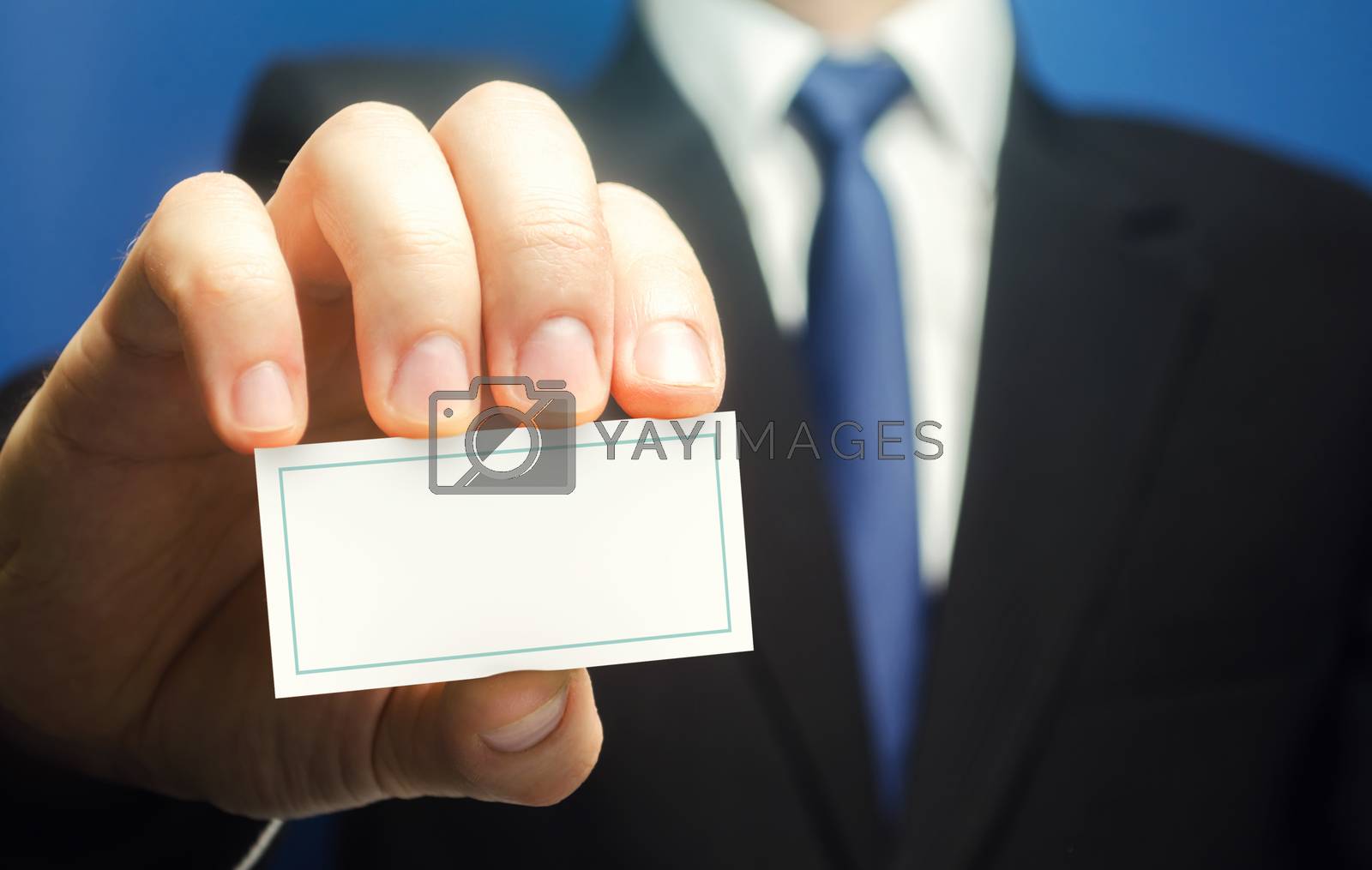 Royalty free image of Businessman introduces himself with a business card. Presentation, hands over contacts to client. Agent offers his services. Solidity and style. Business advertising. Attracting new customers buyers. by iLixe48