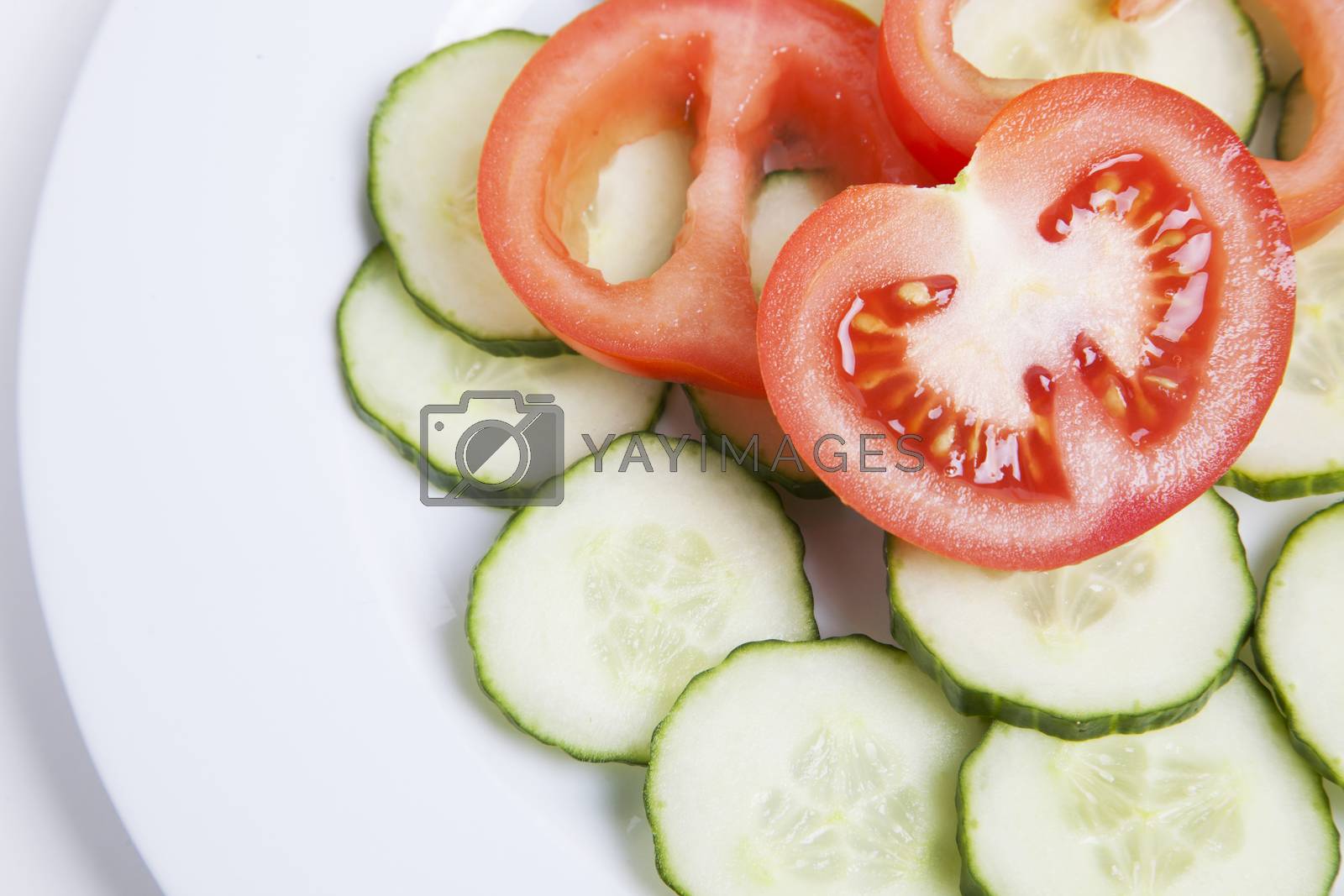 Royalty free image of Close-up of sliced tomatoes and cucumbers in plate by moodboard