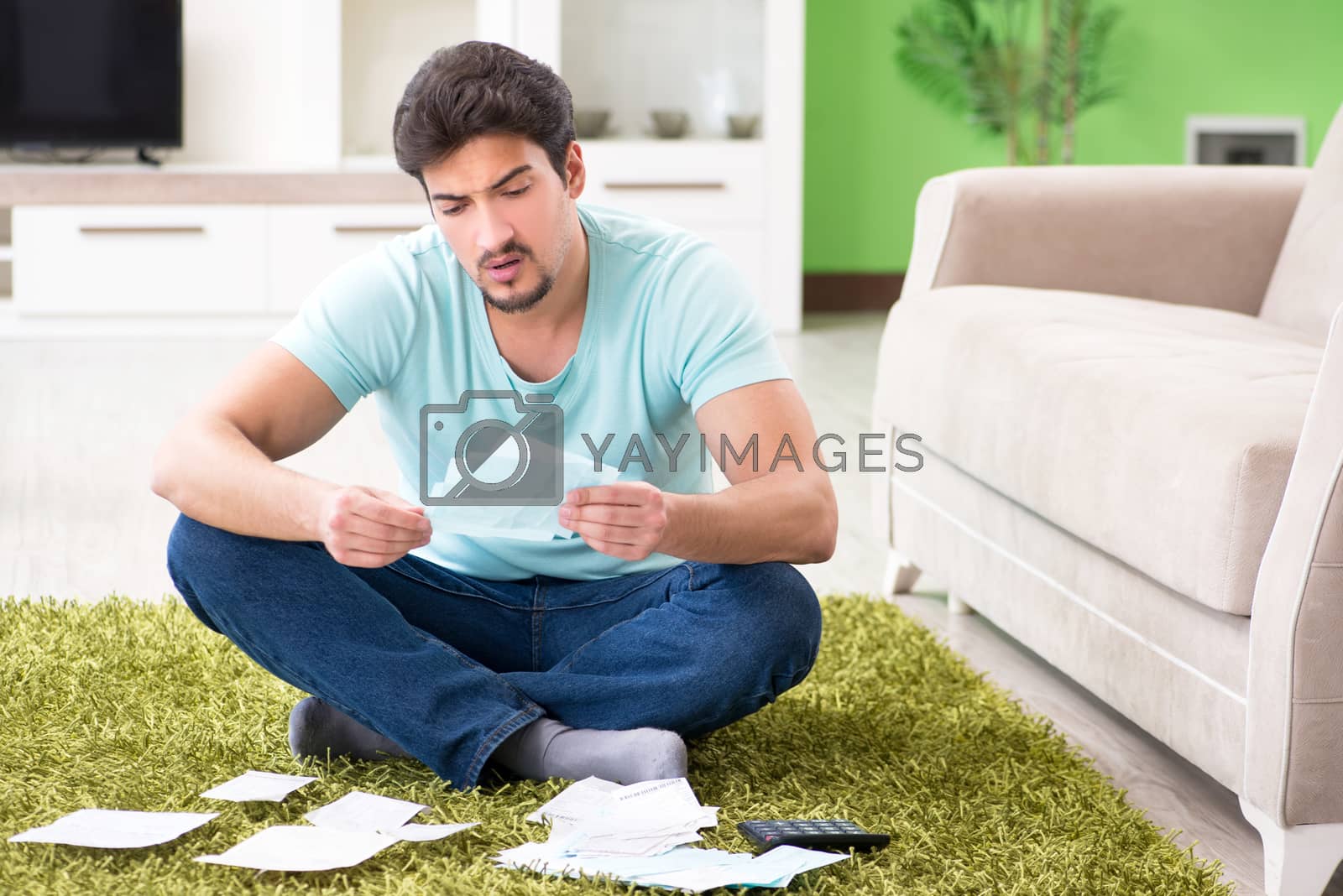 Royalty free image of Young man struggling with personal finance and bills by Elnur