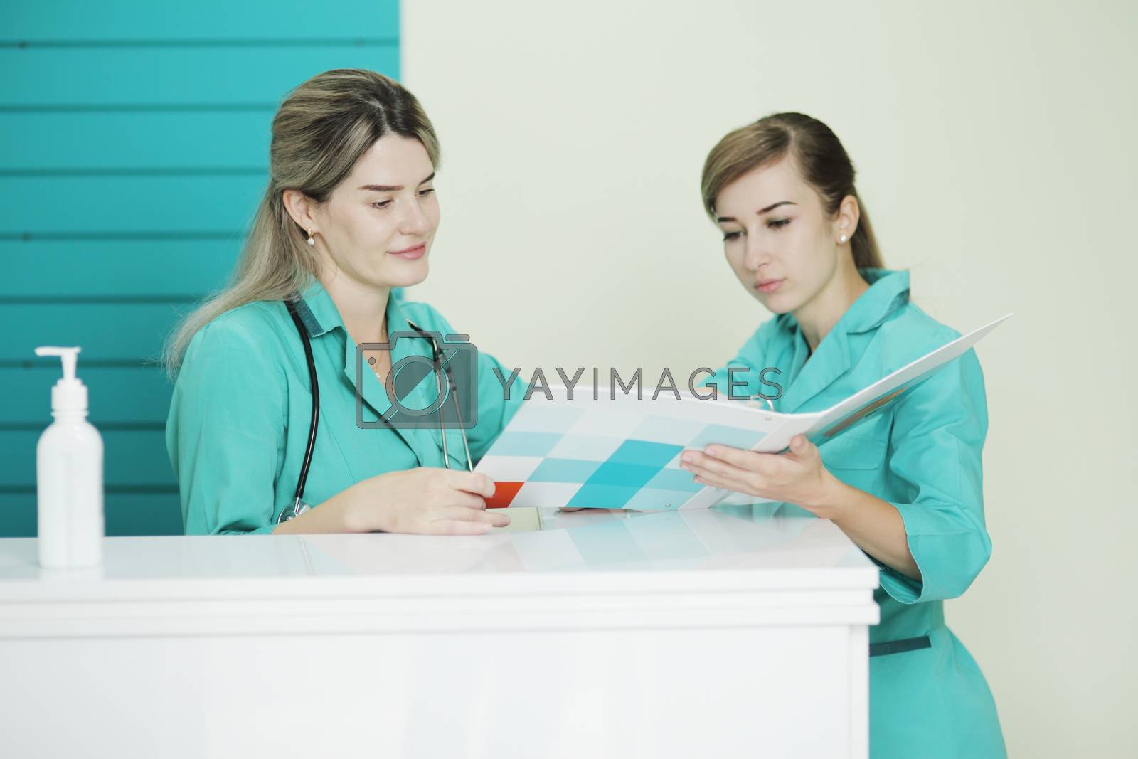 Royalty free image of Two female doctor or nurse discussing patient treatment. Stethoscope on the neck by selinsmo