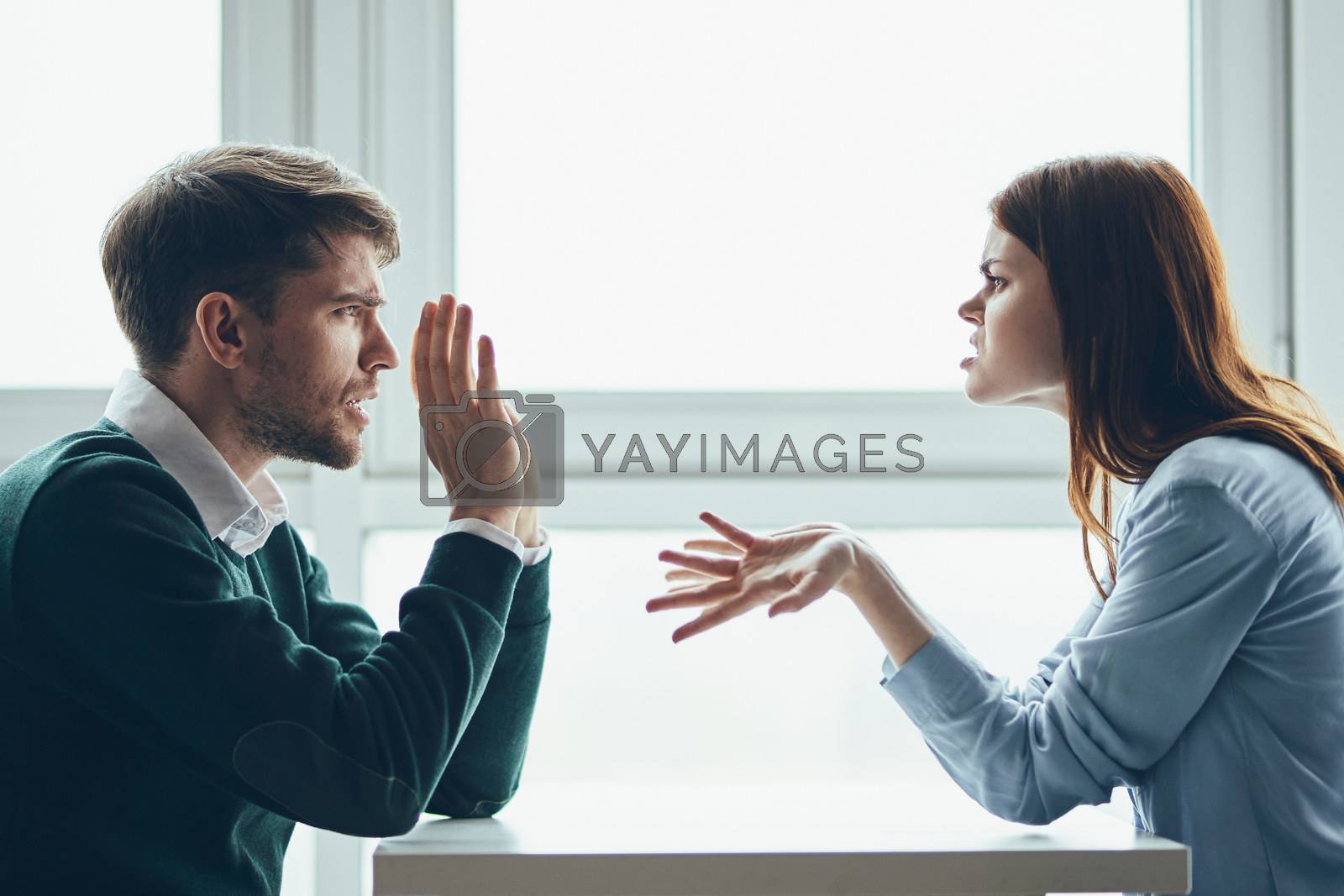 Man and woman at the table sport conflict gesture hands quarrel