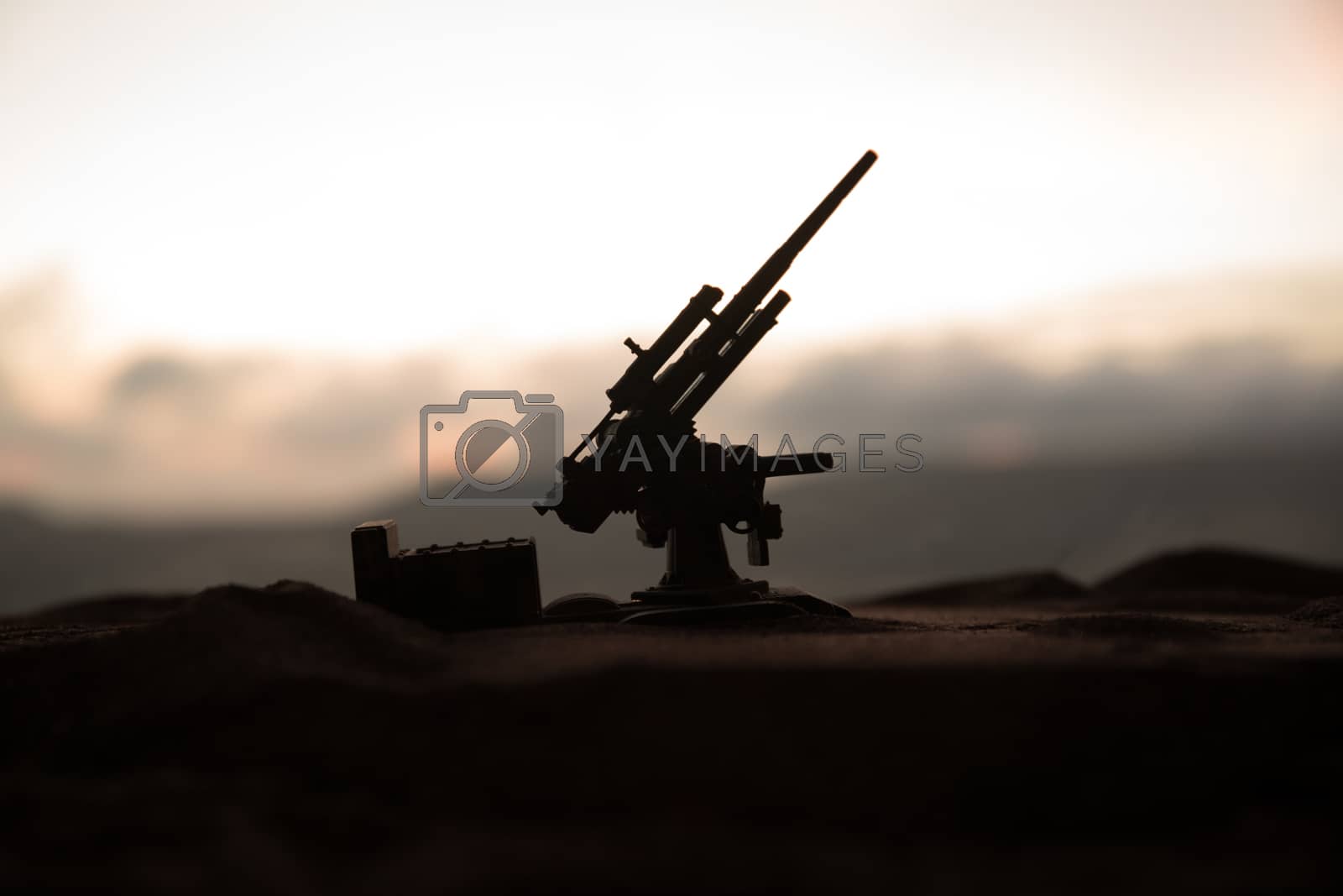 Silhouette of anti-aircraft cannon on battlefield during sunset time. Creative artwork table diorama. Selective focus. , World War Soldiers Silhouettes Below Cloudy Skyline at sunset.