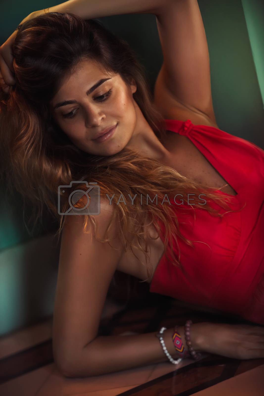 Fashion Portrait of a Beautiful Model Dressed in Red Dress. Stunning Female with Long Hair and Perfect Skin. Authentic Beauty of Young Woman.