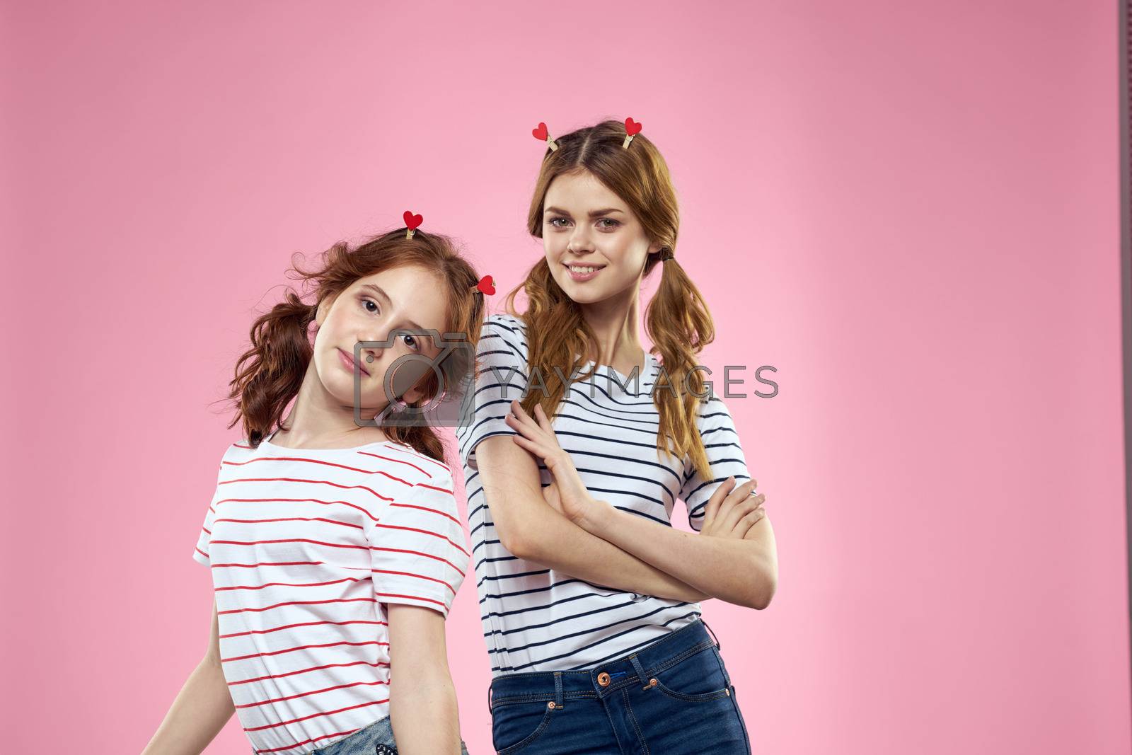 Cheerful mom and daughter joy lifestyle studio pink background family. High quality photo
