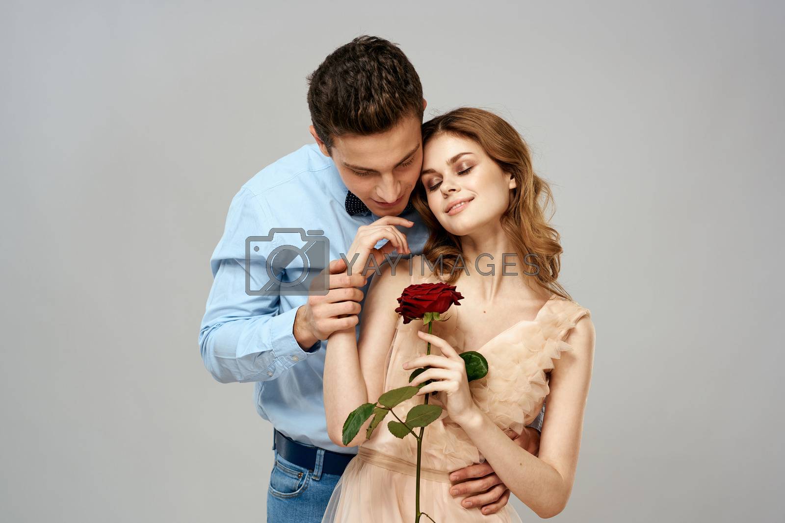 Young couple hugs romance dating lifestyle relationship light background red rose. High quality photo