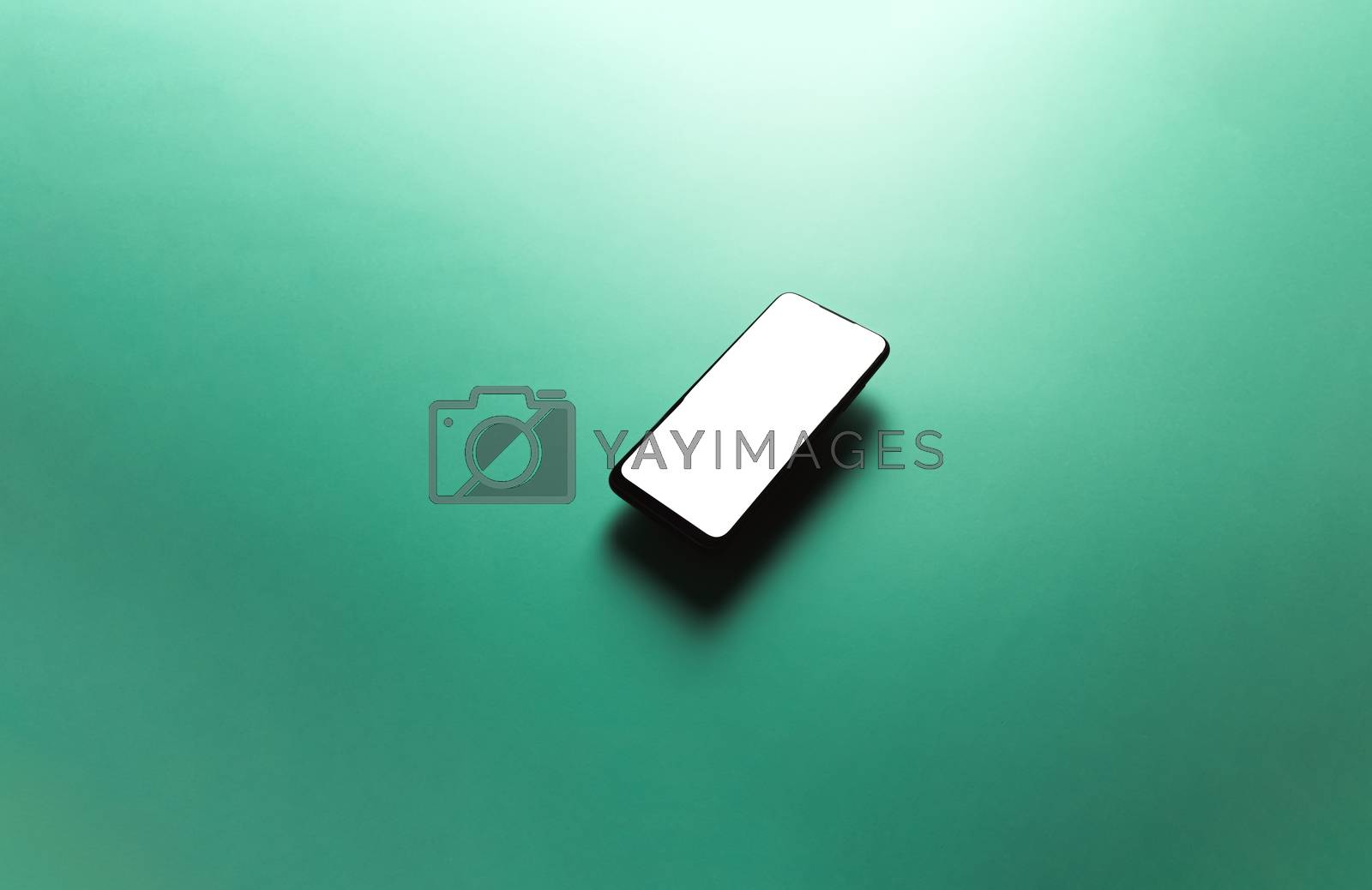 Royalty free image of Minimalistic mock up flat image design with a floating mobile phone with copy space and white scree to write over it over a flat green background by AveCalvar