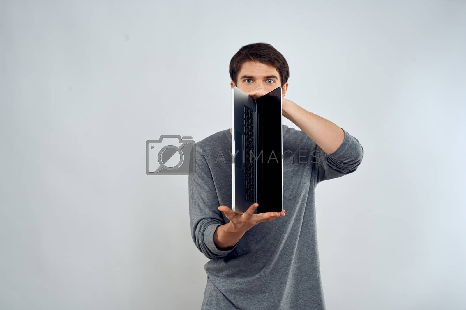 man holding laptop technology internet work communication light background. High quality photo