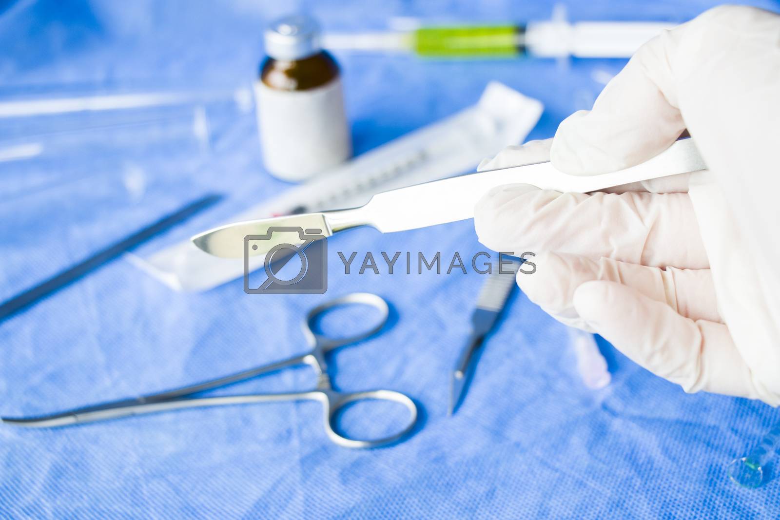 Royalty free image of Surgery knife holding on the white background, studio shot. Operation equipment. Surgery procedure. by Taidundua