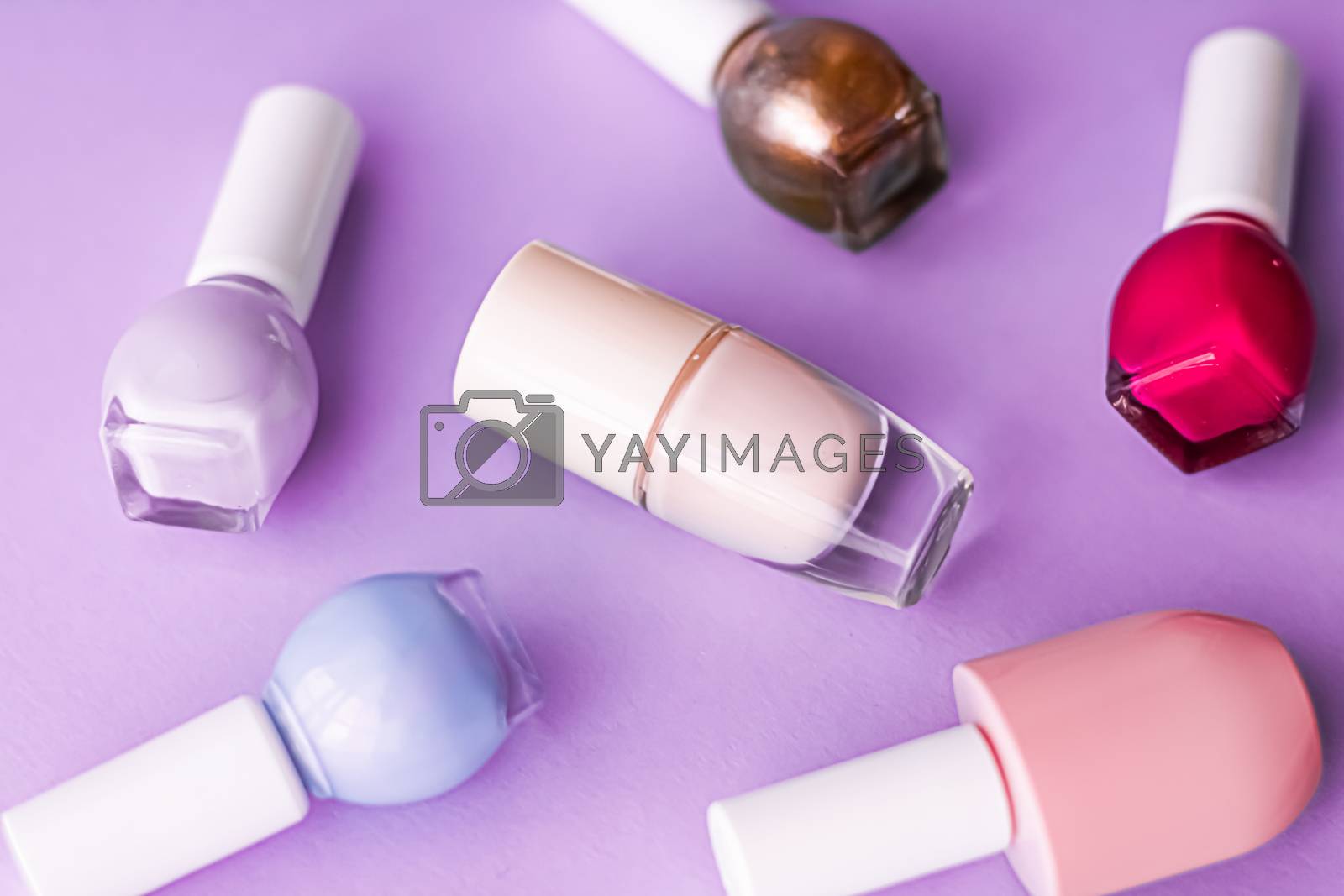 Royalty free image of Nail polish bottles on purple background, beauty brand by Anneleven