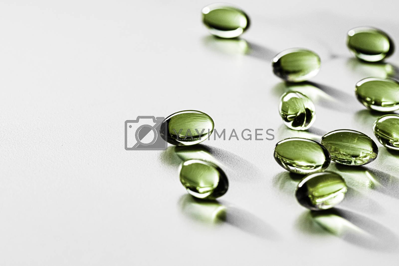 Royalty free image of Green herbal capsules for healthy diet nutrition, pharma brand s by Anneleven