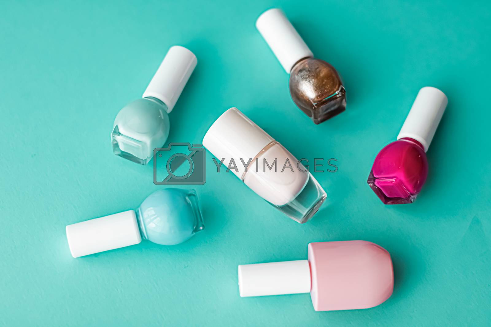 Royalty free image of Nail polish bottles on green background, beauty brand by Anneleven