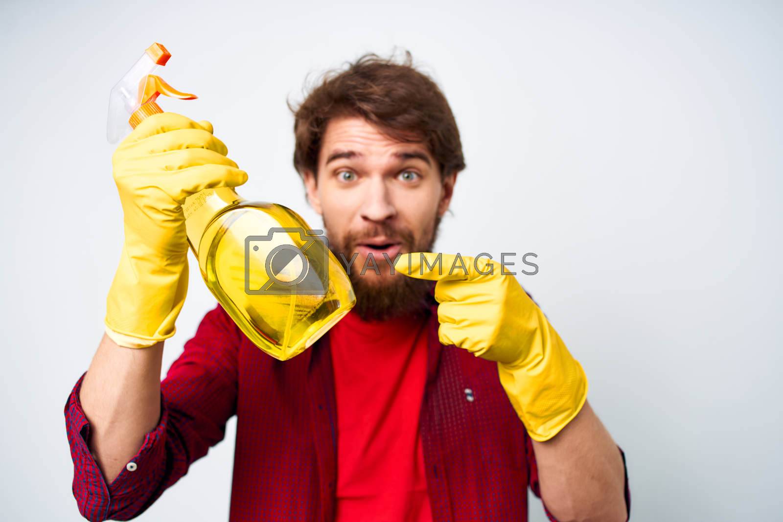Royalty free image of Man in rubber gloves detergent emotions red shirt housework by SHOTPRIME