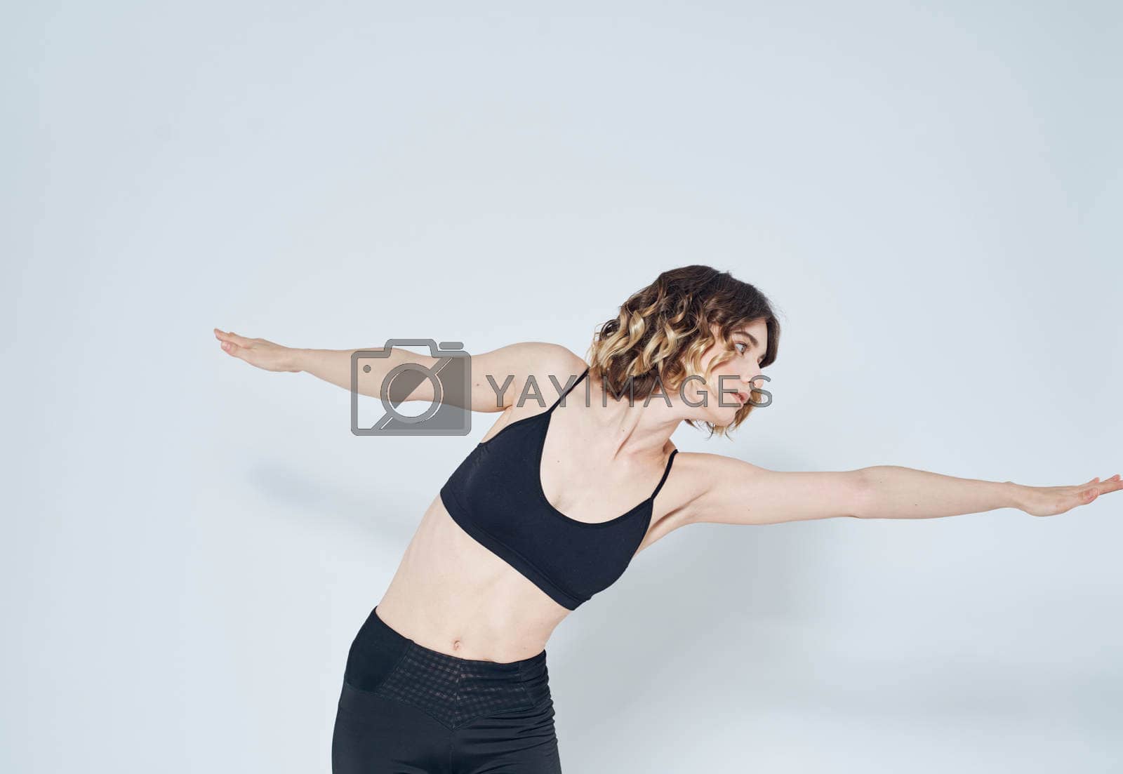 Woman gestures with her hands on a light background sport fitness leggings model. High quality photo