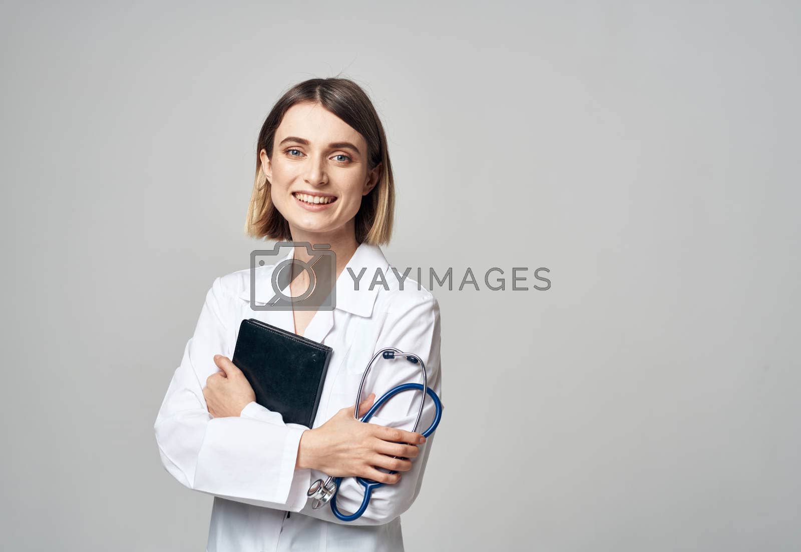 Royalty free image of woman doctor with stethoscope and medical gown documents in hands by SHOTPRIME