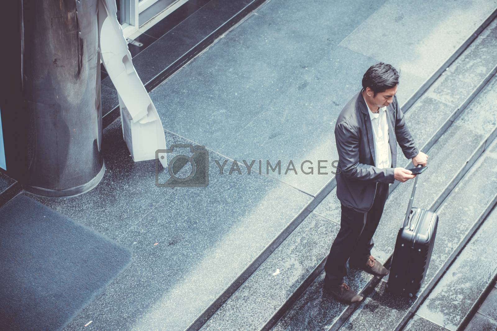 Royalty free image of Asian elegant businessman wear suit talking mobile phone while w by nnudoo