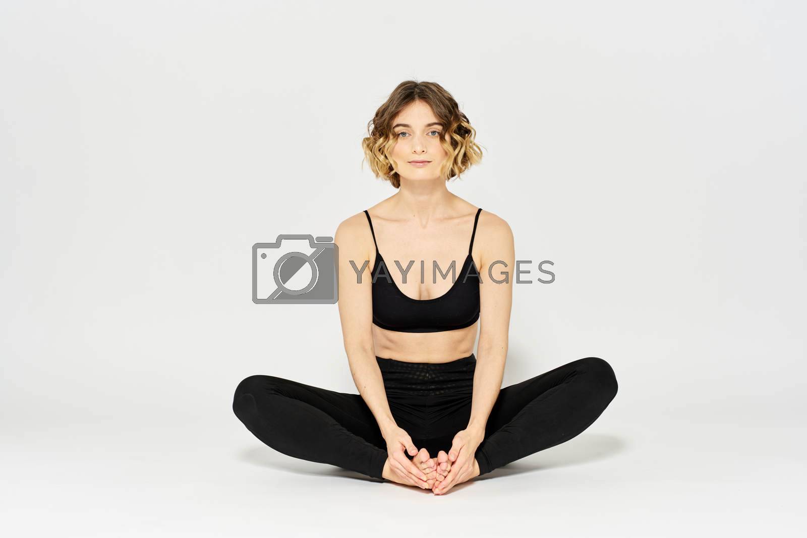 Woman in leggings meditate in a light room with her legs crossed yoga asana. High quality photo