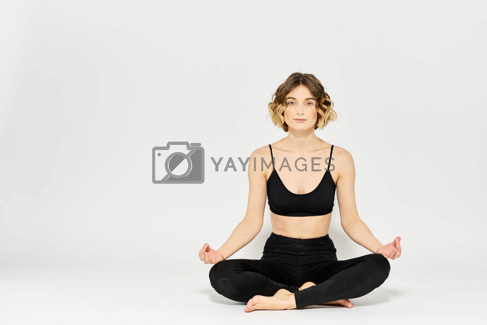 Yoga asana woman crossed legs meditation light background room. High quality photo