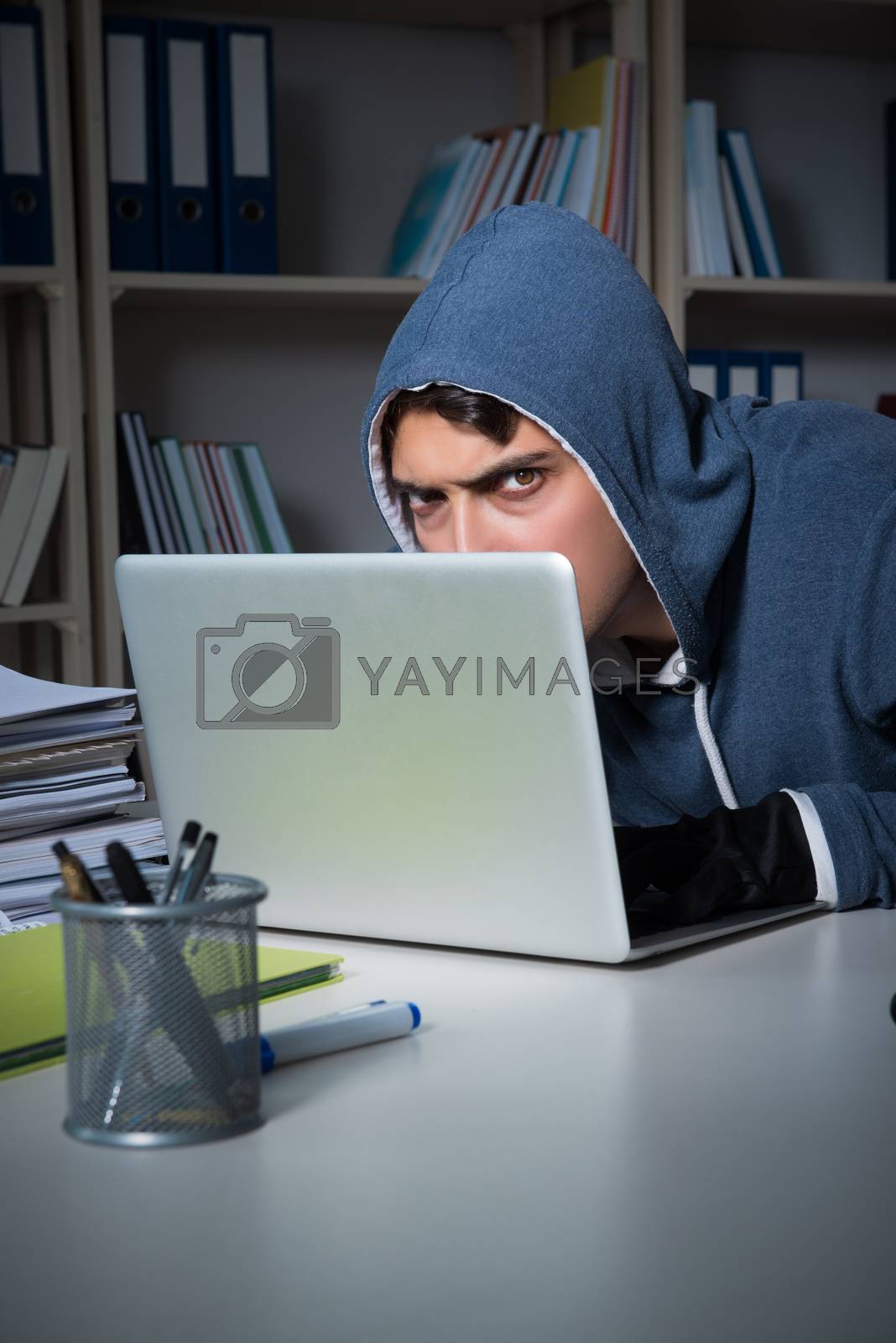 Royalty free image of Young hacker hacking into computer at night by Elnur