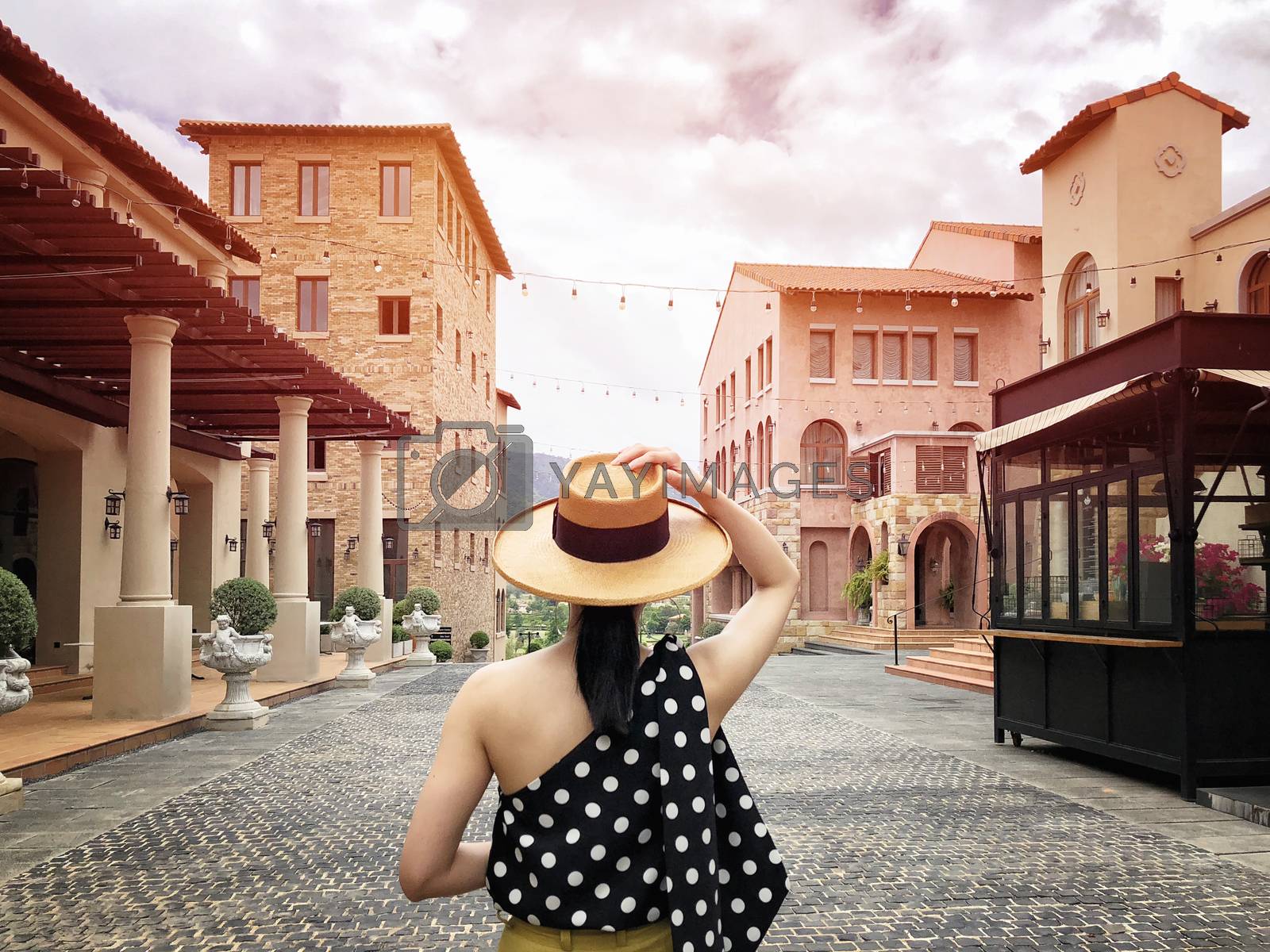 Royalty free image of Woman wearing a planter panama hat visiting an Italian style vil by Surasak