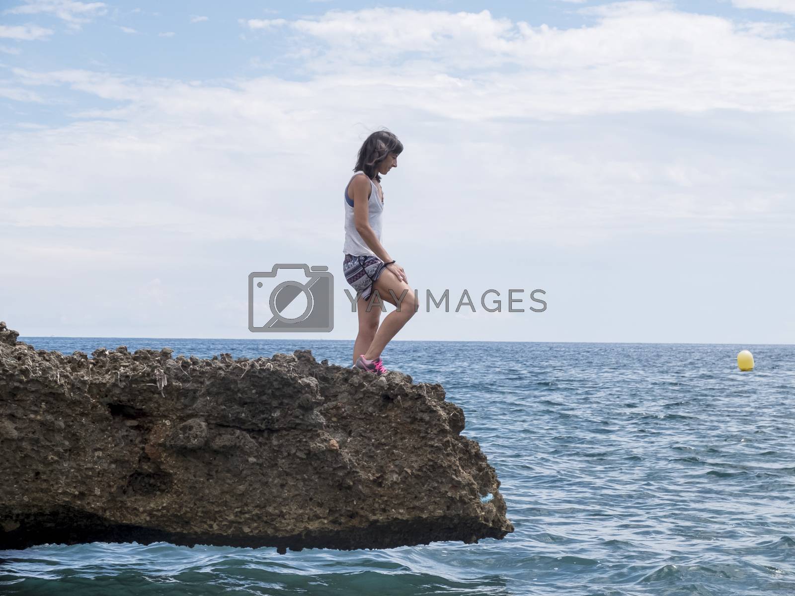 Royalty free image of Side view of a woman standing on sea rocks by raferto1973