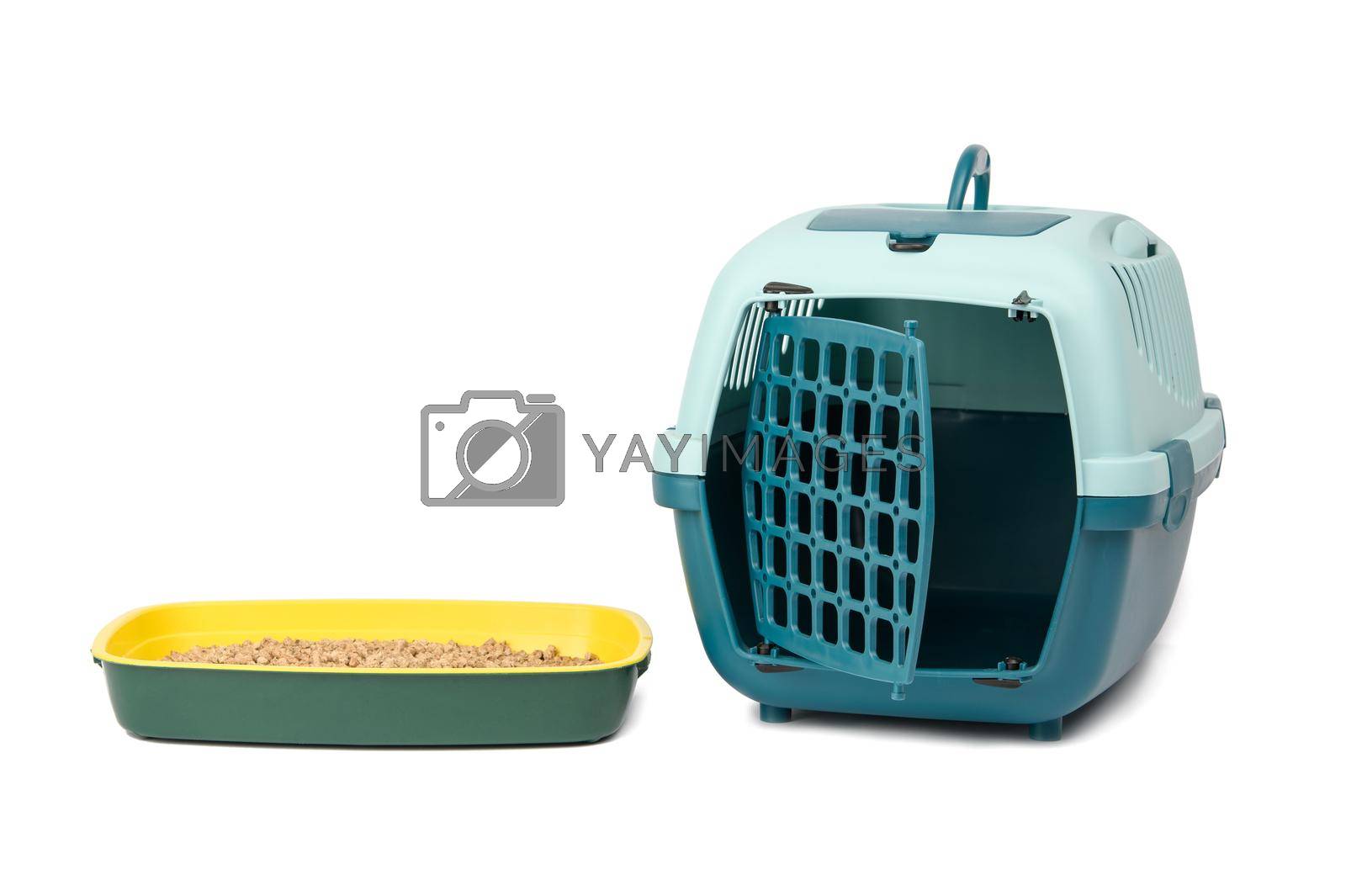Royalty free image of large plastic carrier cage for cats and dogs and cat litter box filled with pressed sawdust by ndanko