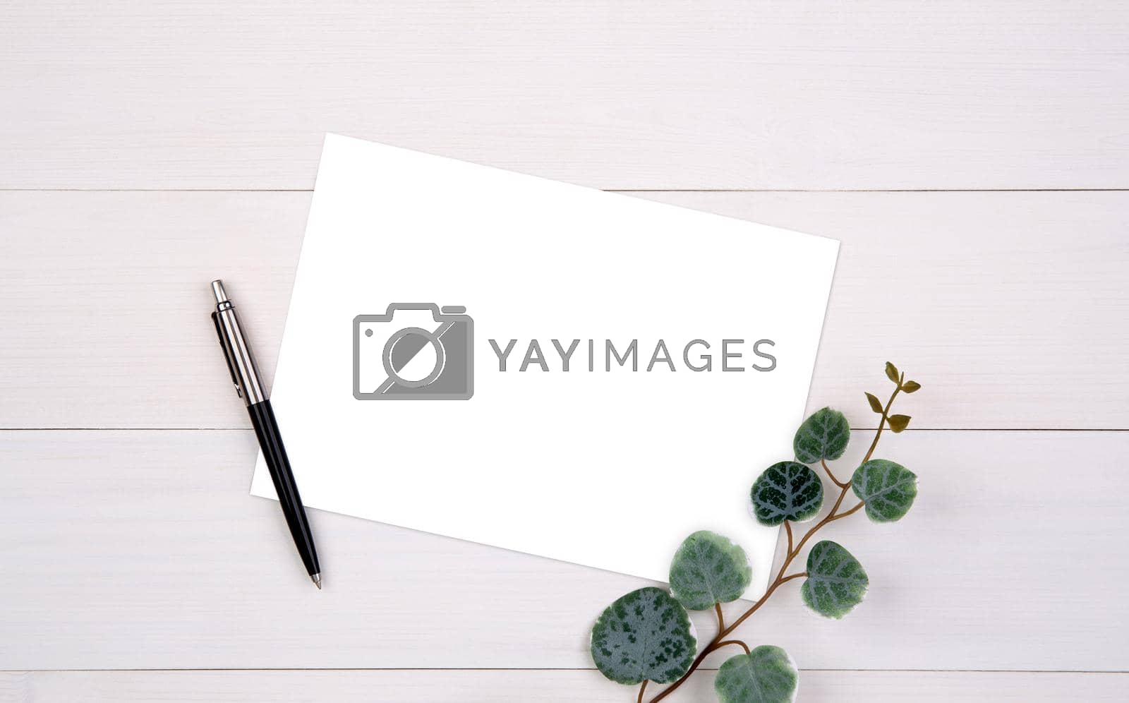 Royalty free image of Blank paper sheet copy space with mockup and leaf on wooden table, poster and invitation, postcard decoration your design or branding, simplicity and minimal, nobody, flat lay, top view. by nnudoo