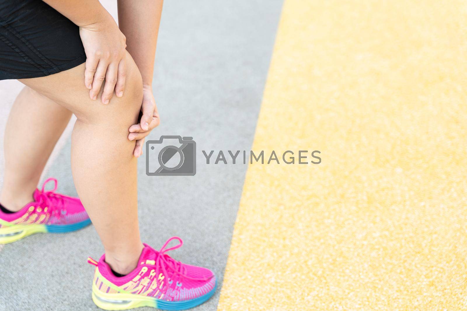Royalty free image of Female fatty runner athlete leg injury and pain. Hands grab painful knee while running in the park. by mikesaran