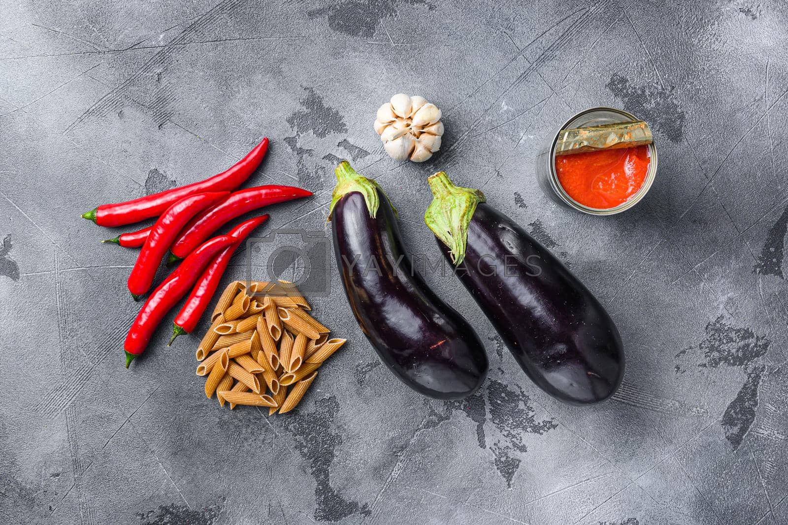 Royalty free image of Aubergine penne ingredients eggplant pasta, pepper tomatoe sauce, on grey background top view. by Ilianesolenyi