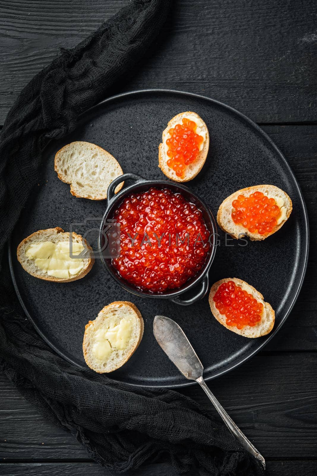Royalty free image of Canape with Red Salmon Caviar for New Year, on black wooden table background, top view flat lay by Ilianesolenyi