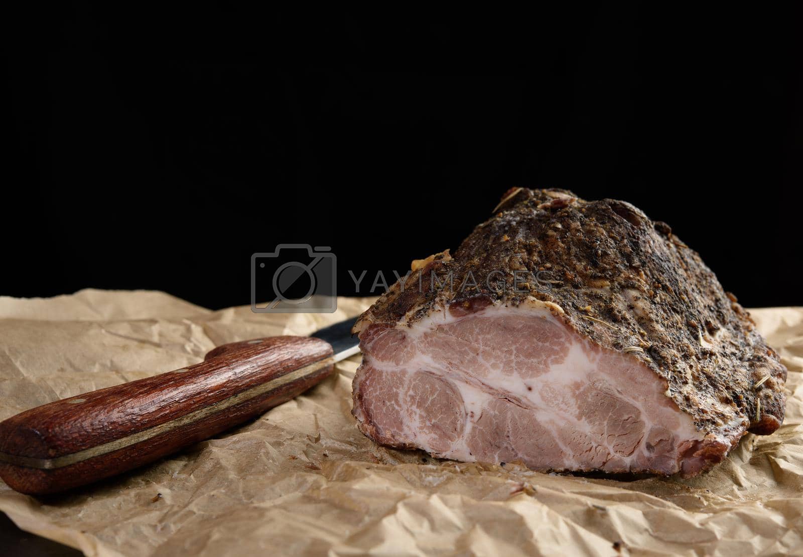 Royalty free image of a baked piece of spiced pork neck on brown parchment paper by ndanko