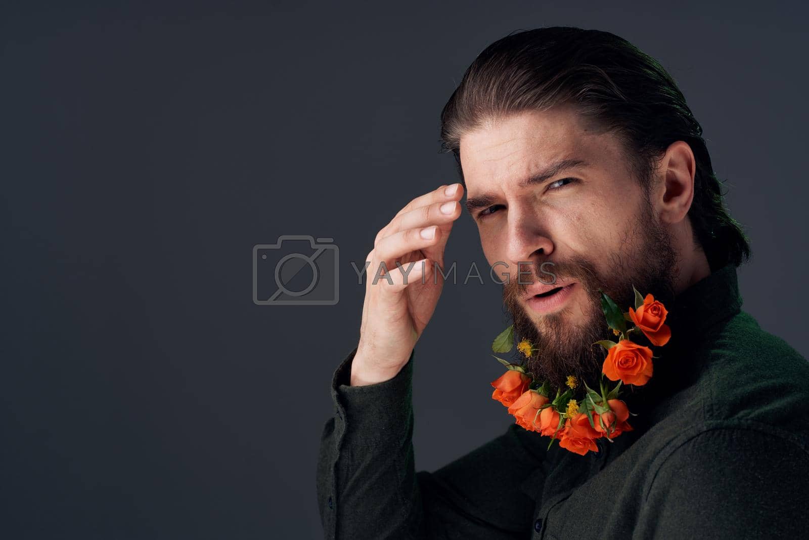 handsome man flowers in a beard decoration romance dark background. High quality photo