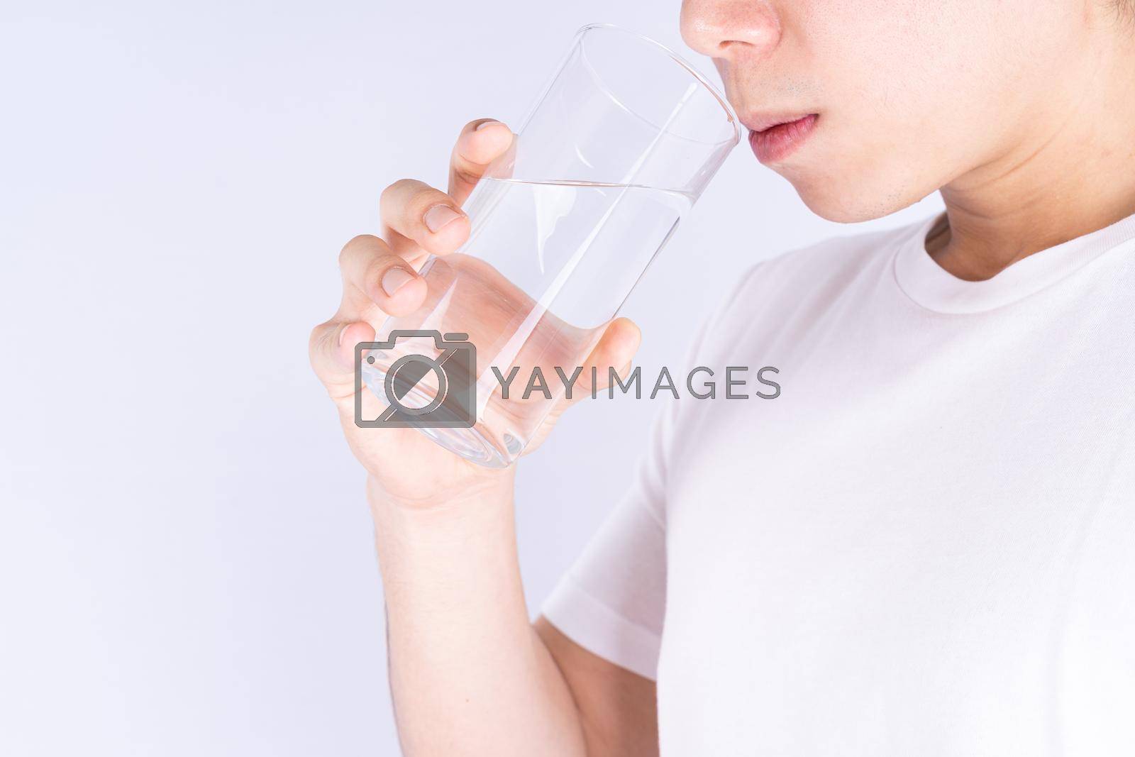 Royalty free image of Man drinking water isolated grey background. Clean drinking water in clear glass. by mikesaran