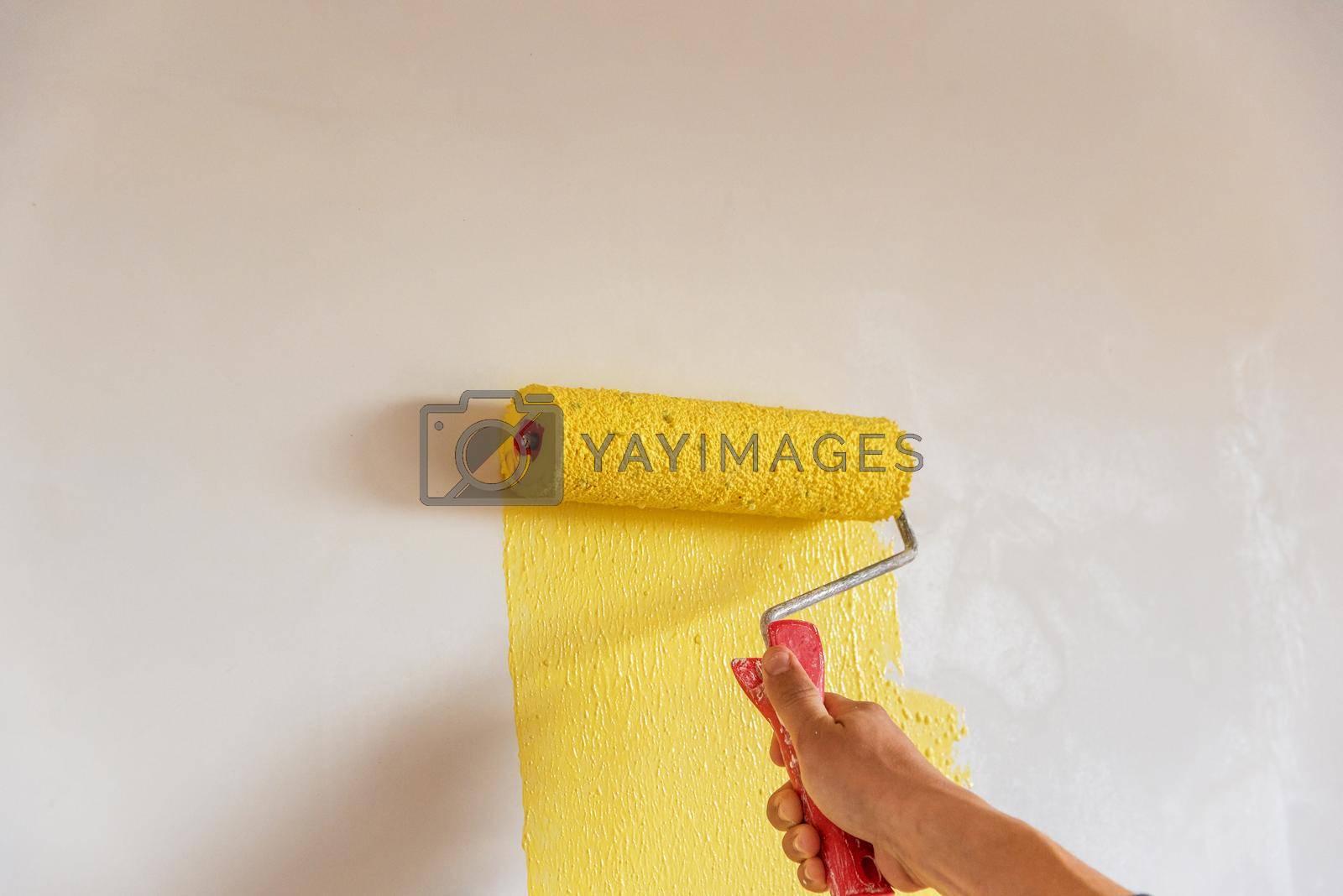 Royalty free image of Workman painting the wall in yellow.  by ba11istic