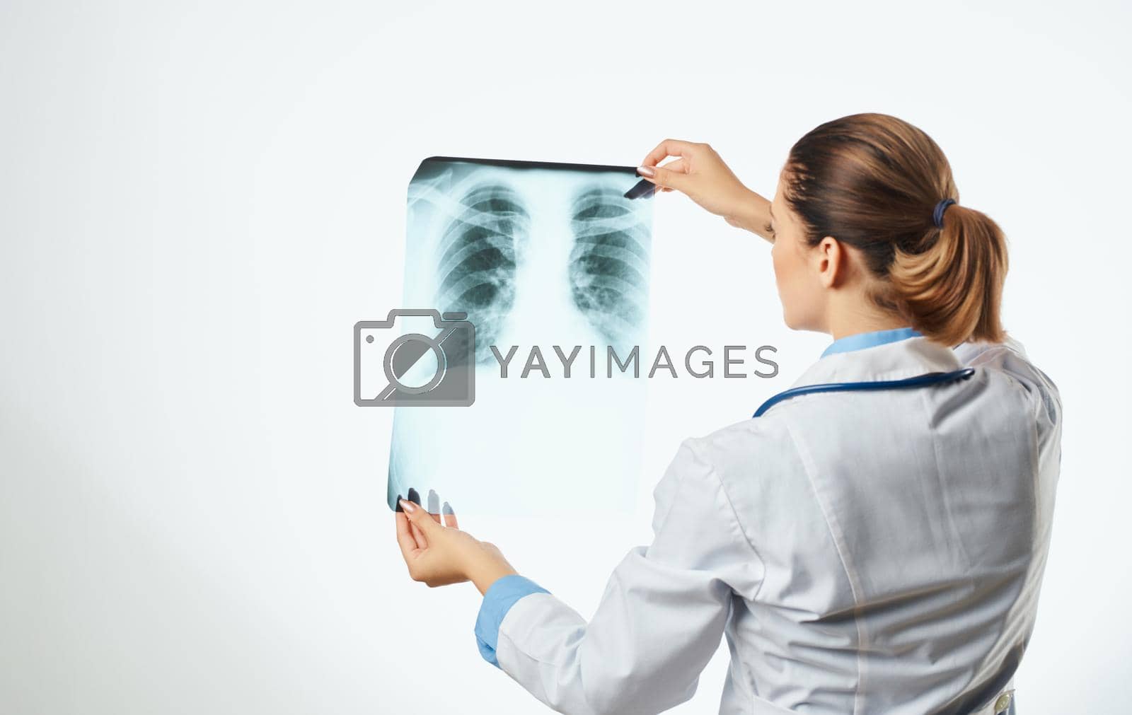 Royalty free image of Woman doctor examines x-ray and medical gown glasses with stethoscope by SHOTPRIME