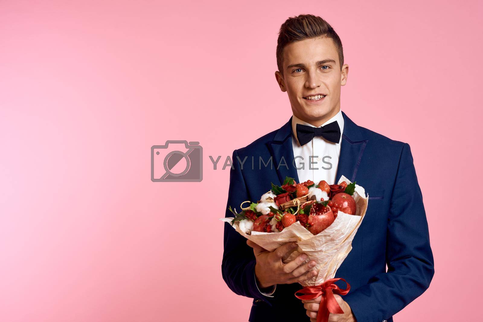 man in a suit bouquet of flowers romance date pink background. High quality photo