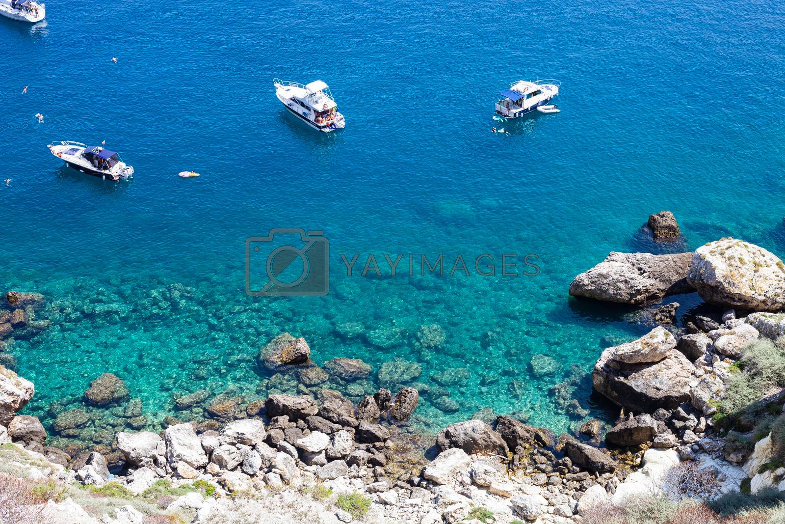 Royalty free image of Boats near a rock stone coast. San Domino island, Italy: scenic view of tipycal rocky coastline.  by marylooo