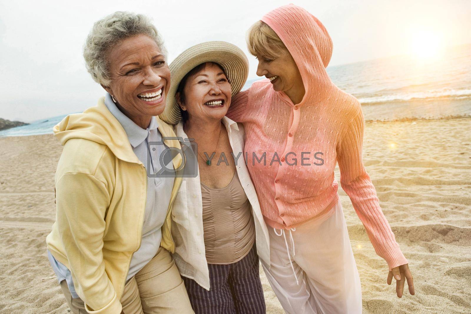 Royalty free image of Portrait of happy multi ethnic middle aged female friends enjoying vacation at beach by moodboard