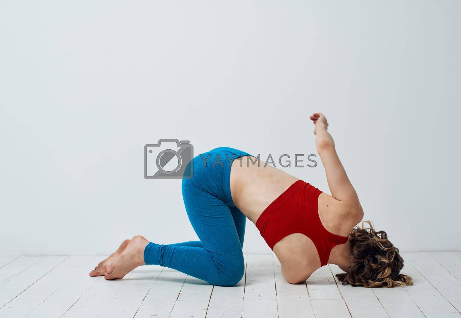A woman is kneeling on the floor with her arm bent and yoga asana exercises. High quality photo