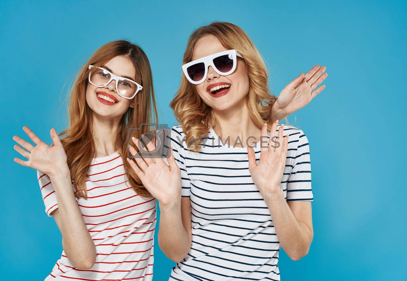 two pretty women gesticulate with hands fun friendship joy lifestyle blue background. High quality photo