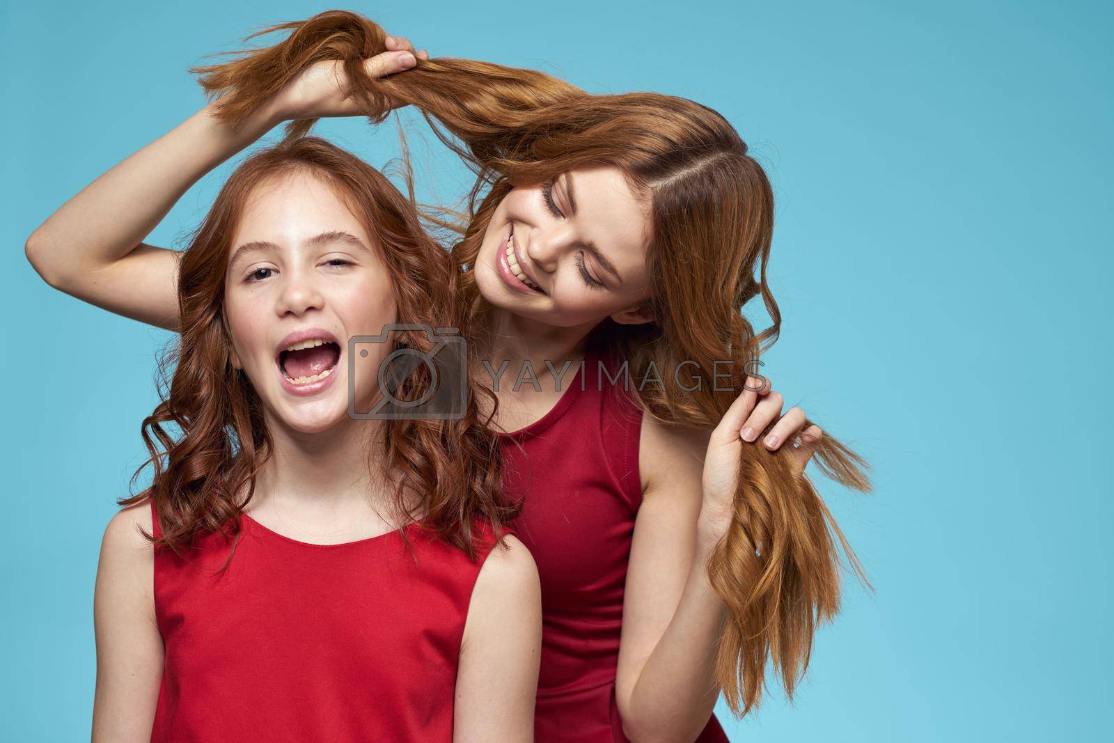 Cheerful mom and daughter hugs joy lifestyle communication friendship blue background. High quality photo