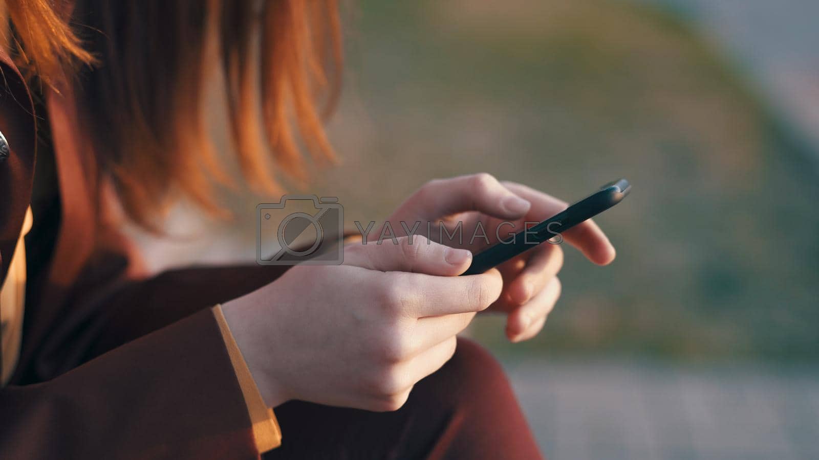 woman with phone in hands outdoors communication close-up. High quality photo