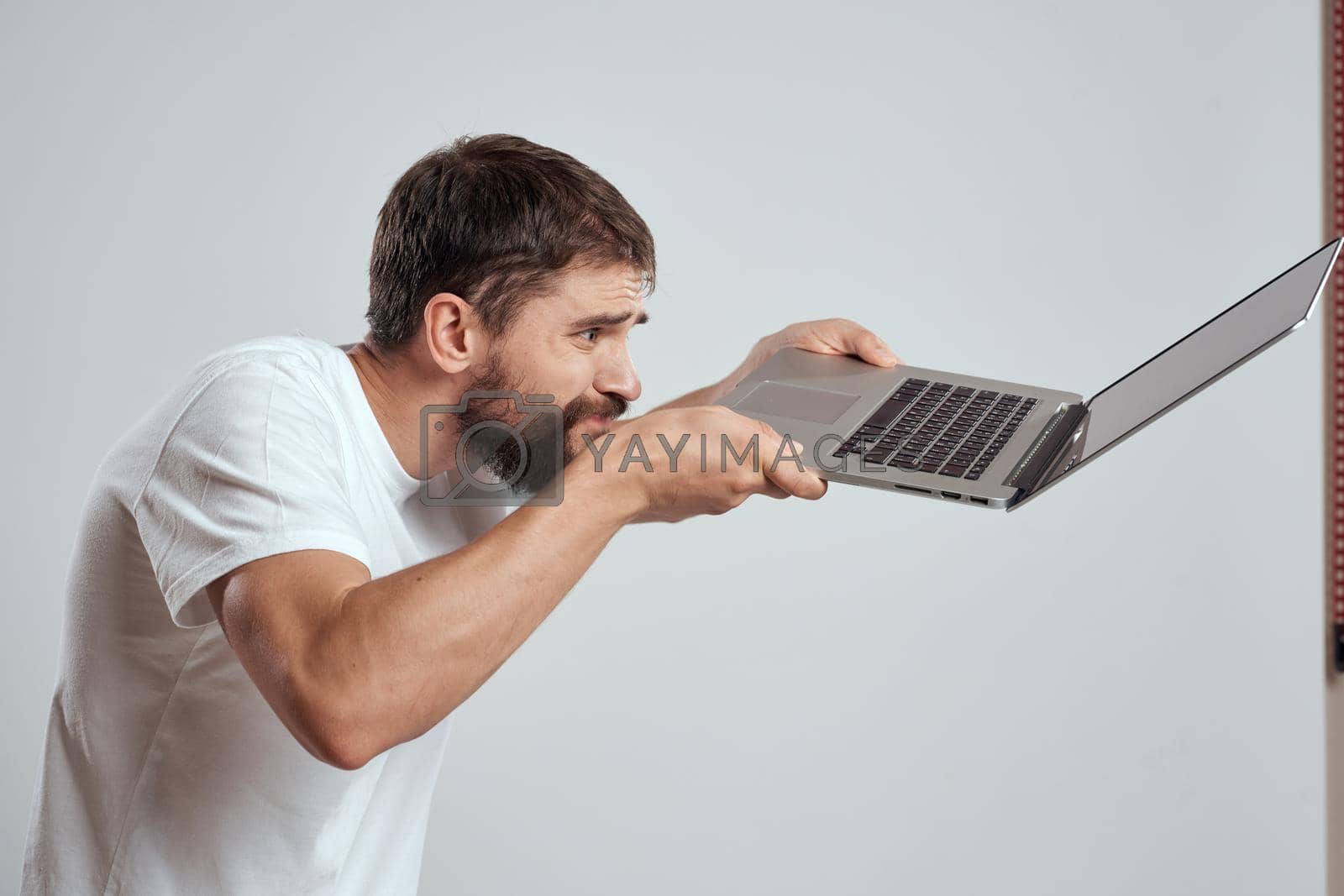 man in t-shirt laptop in hands technology communication studio. High quality photo