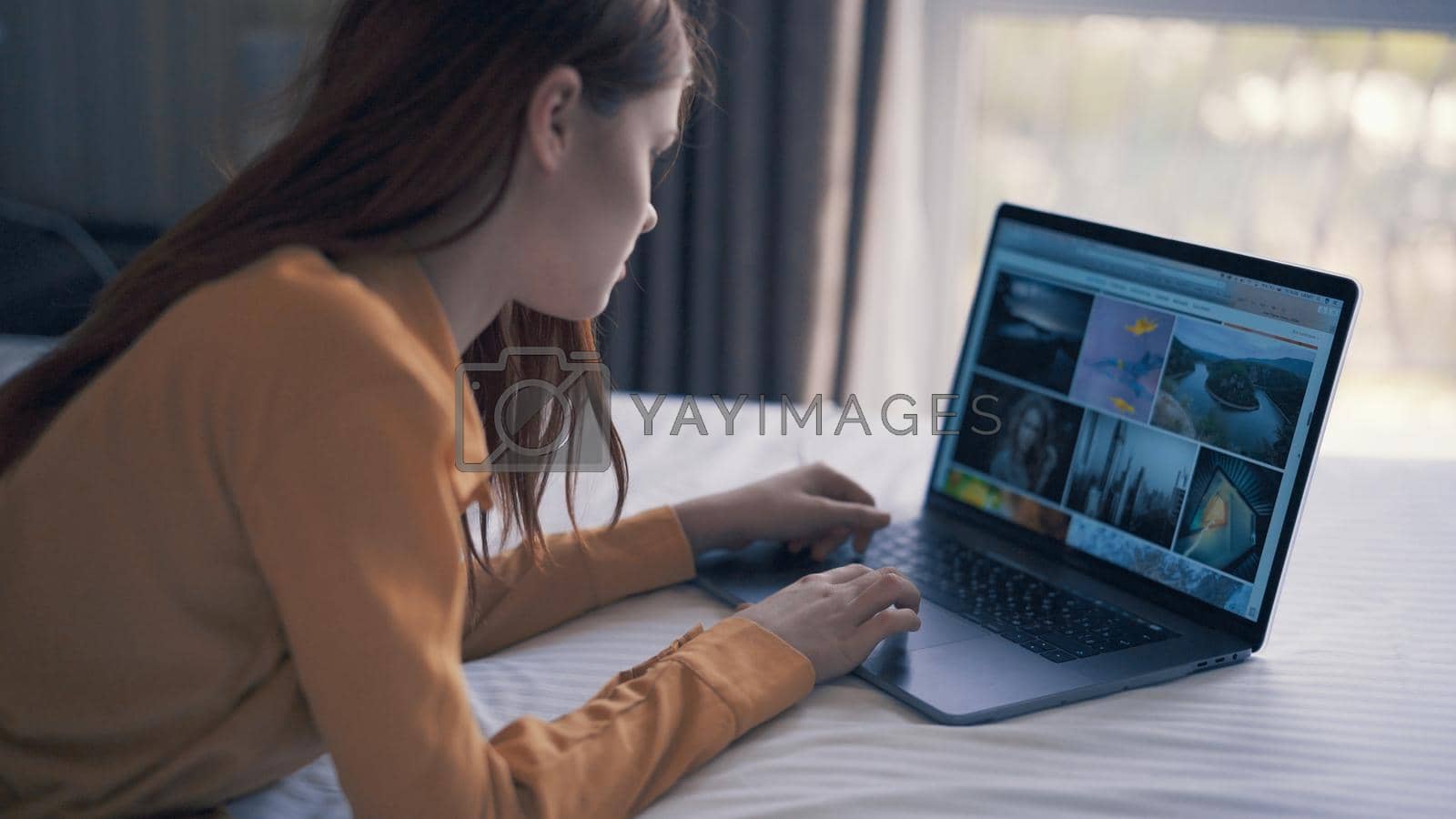 woman lies in bed in front of laptop freelance communication. High quality photo